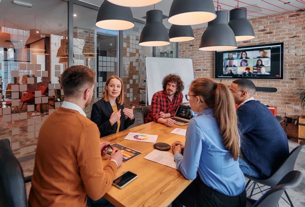 Medarbetare som samarbetar och diskuterar arbete och utveckling runt ett bord - Spiransia Medveten Arbetsplats, koncept för utveckling av arbetsmiljö, samarbete, psykisk hälsa, inre förmågor och motivation. Self-Determination Theory SDT, Inner Development Goals, IDG. Organisation, team, arbetsuppgifter, implementering, vardagsträning, grupparbete.
