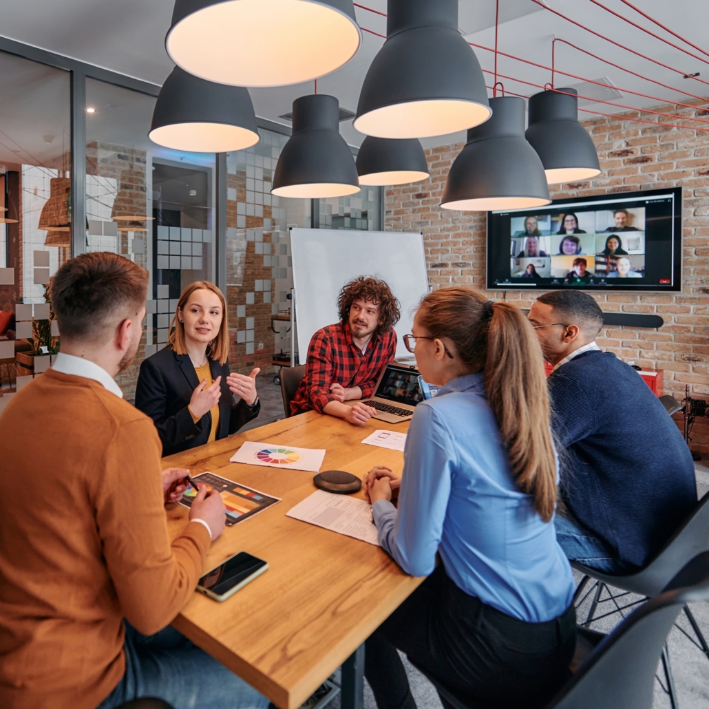 Medarbetare som samarbetar och diskuterar arbete och utveckling runt ett bord - Spiransia Medveten Arbetsplats, koncept för utveckling av arbetsmiljö, samarbete, psykisk hälsa och motivation. Self-Determination Theory SDT, Inner Development Goals, IDG. Organisation, team, arbetsuppgifter, implementering, vardagsträning, grupparbete.