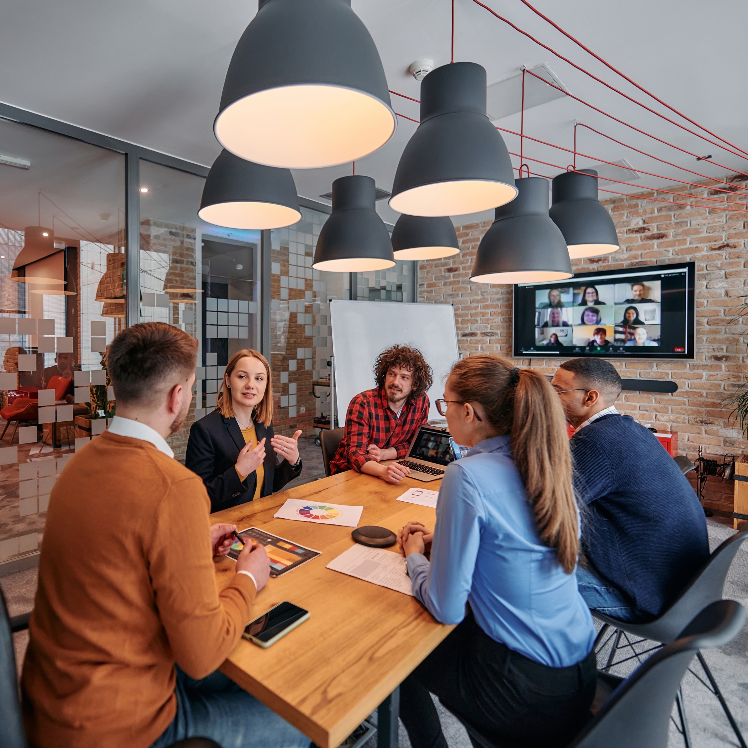 Medarbetare diskuterar på möte Medarbetare som samarbetar och diskuterar arbete och utveckling runt ett bord - Spiransia Medveten Arbetsplats, koncept för utveckling av arbetsmiljö, samarbete, psykisk hälsa, inre förmågor och motivation. Self-Determination Theory SDT, Inner Development Goals, IDG. Organisation, team, arbetsuppgifter, implementering, vardagsträning, grupparbete.